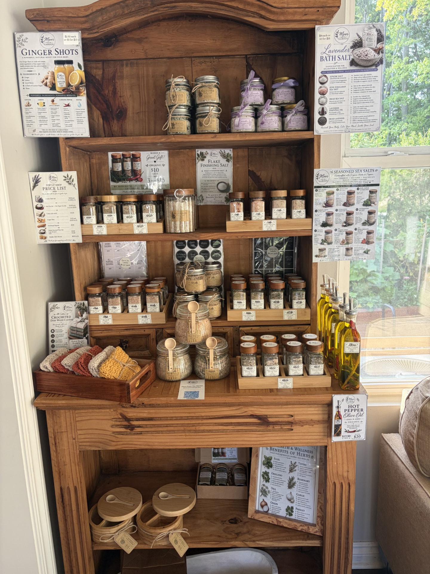 Wooden display cabinet filled with Cindy's handmade salts, oils and goods